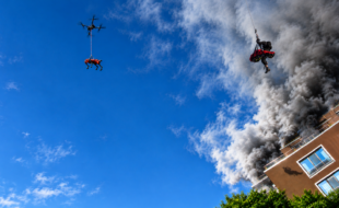 Aerial rescue operation amid thick smoke and flames, demonstrating advanced emergency response and high-altitude search and rescue capabilities.